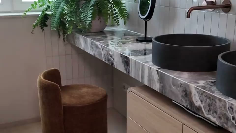 Badkamer met marmerlook wastafelblad en donkere waskom, uit de film van de Oktober Woonmaand